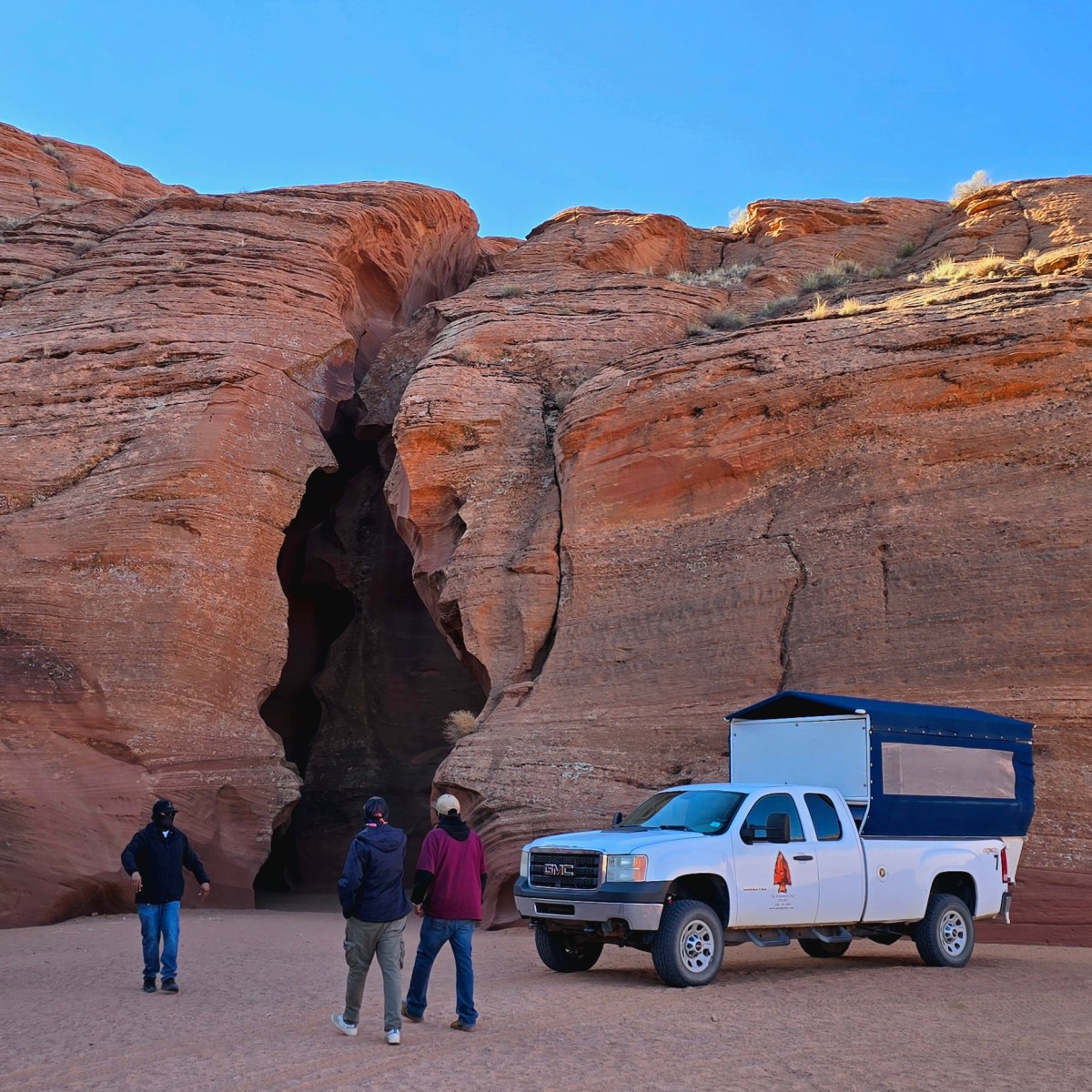 a group of people standing in front of a canyon
